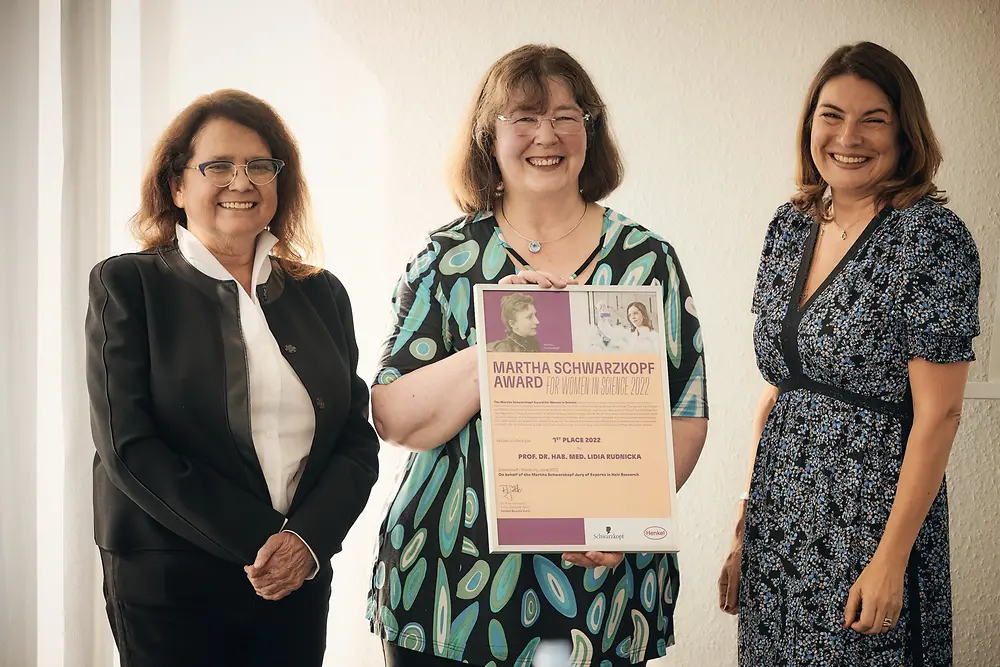 Award winner Prof. Dr. hab. med. Lidia Rudnicka stands to the left of Dr. Andrea Sättler and Sylvie Nicol.