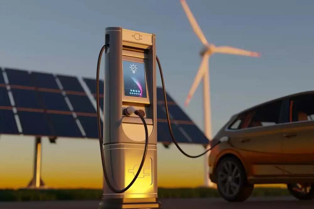 Nabíjacia stanica pre elektromobily so solárnymi panelmi a veternými turbínami v pozadí.