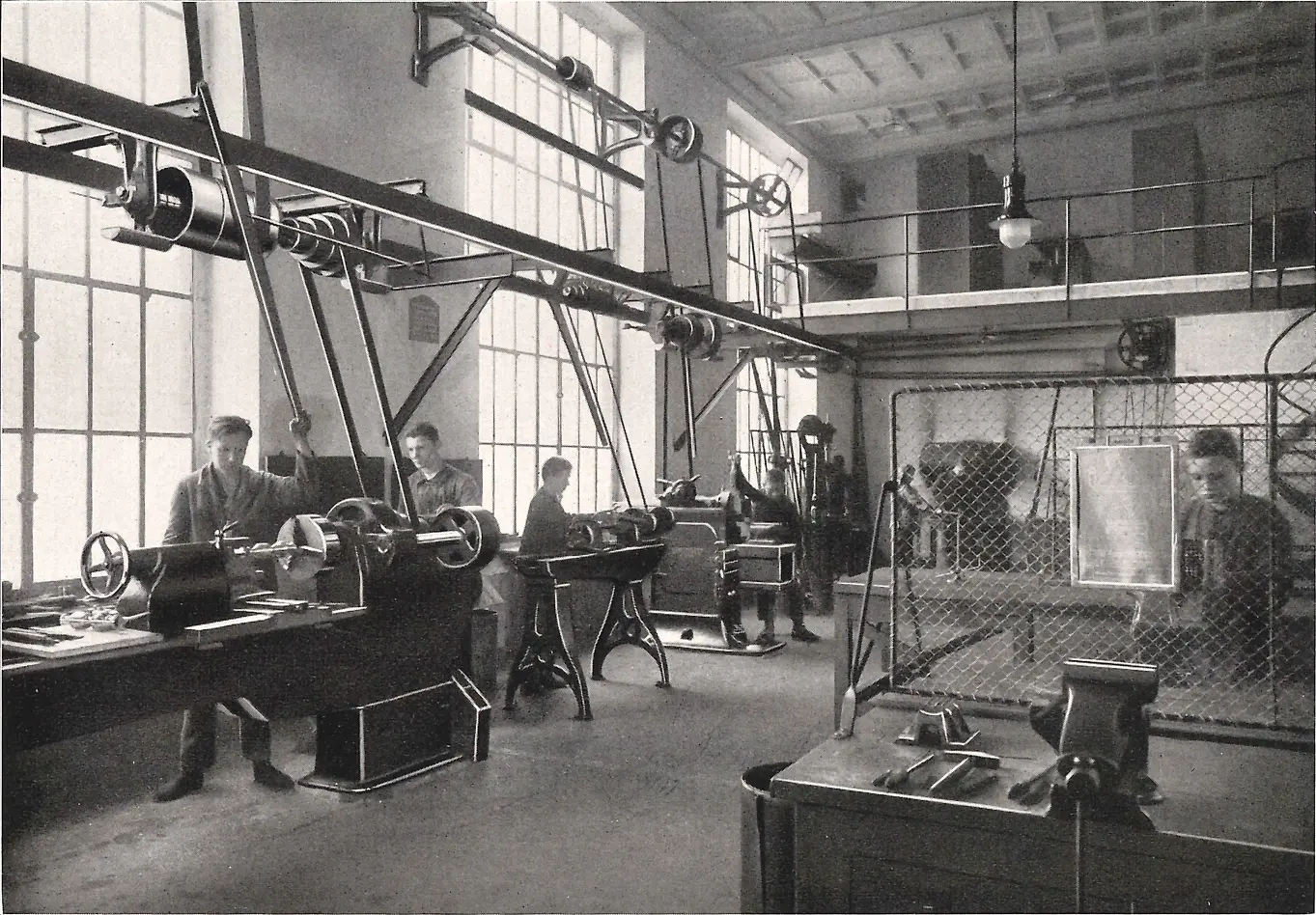 Učni pracujúci na strojoch v kovospracujúcej dielni.